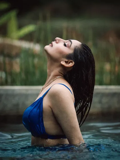 A serene moment captured during a poolside shoot. The soft, natural light and the model's relaxed pose create a feeling of tranquility and elegance.