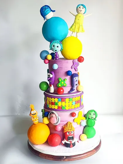The full view of the epic 'Inside Out' cake, a true labor of love. It combines real cake tiers with a dummy tier to achieve this grand height and structure, perfect for a big celebration.