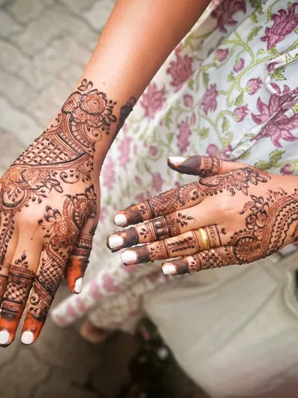 A lovely party mehendi with a mix of floral and paisley elements. The design is dense on the back of the hand and lighter on the palm.