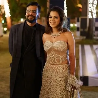 This couple's off-shoulder corset-style lehenga and classic bandhgala is a stunning combination. I can design a similar coordinated look for a modern and stylish reception.
