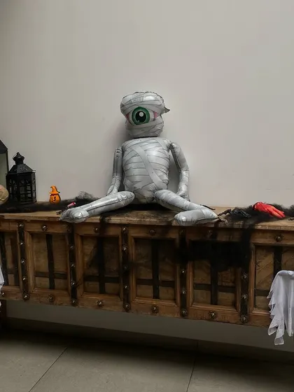 A spooky-cute mummy balloon sitting on a rustic chest. This is a fun and whimsical decoration from one of my Halloween parties, perfect for creating a festive, not-too-scary vibe.