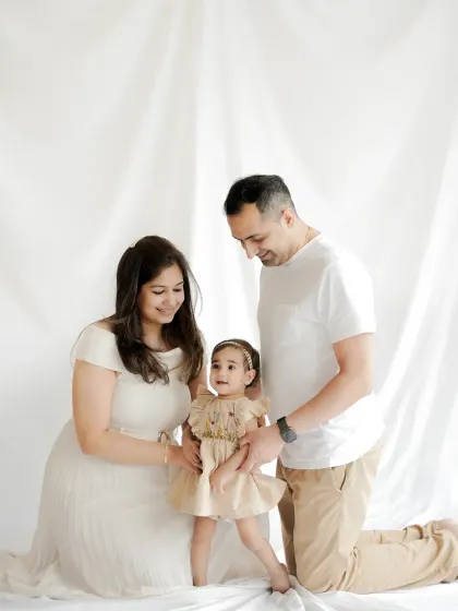 A candid moment of love and laughter. We focus on capturing the natural interactions within your family, like this sweet moment between parents and their little girl.