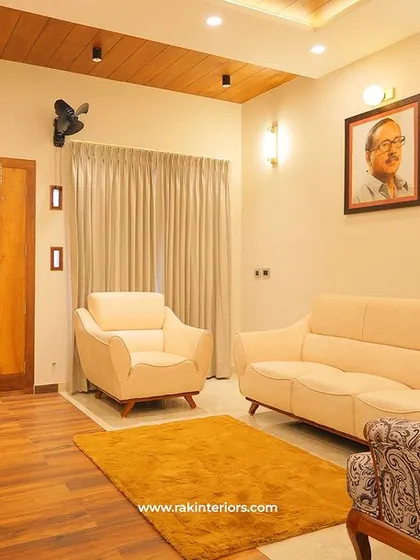 A comfortable and classic living room setup with plush cream sofas and a patterned armchair. The wooden flooring and warm lighting create a cozy and traditional ambiance, perfect for family relaxation.