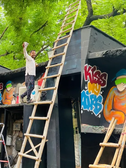 A shot of me during the creation of the "Kiss My Airs" graffiti piece at Sai Garments. This mural, with its poppy colors and sneaker characters, was designed to match the store's street-style energy.