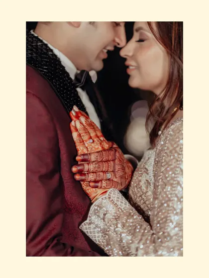 An intimate close-up focusing on the couple's hands and henna. This shot captures the blend of tradition and modern romance, a quiet moment of connection amidst the celebration.