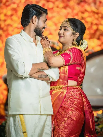 The bride playfully adjusts the groom's chin, a sweet candid moment. His natural, clean look is perfect for these spontaneous shots.