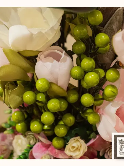 The bright green berries add a pop of color and a touch of realism to this beautiful arrangement of pink and white flowers.