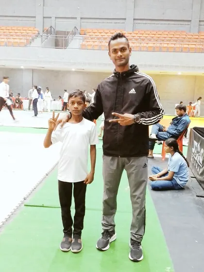 A young Taekwondo athlete poses with his coach at the Member of Parliament Games & Sports Festival. This event saw approximately 150 athletes under 14 compete, showcasing the growing talent in martial arts.