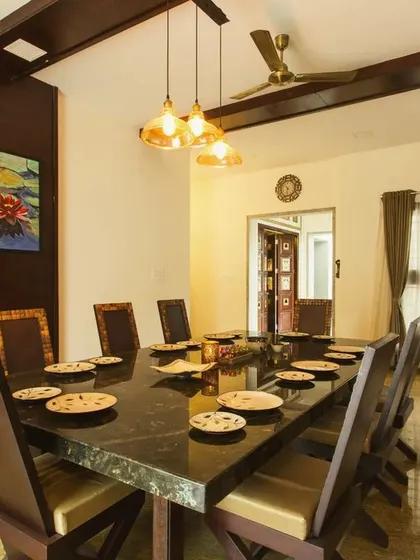 A formal dining area with a dark wood table and chairs, complemented by a coffered ceiling and warm pendant lighting, creating an intimate atmosphere for meals.