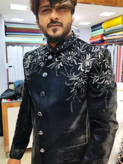 A close-up of the client in the navy blue velvet Jodhpuri, focusing on the intricate floral embroidery.