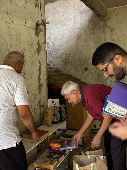 Residents organize books and other items collected during their dry waste drive, ensuring everything goes to the right recycling stream.