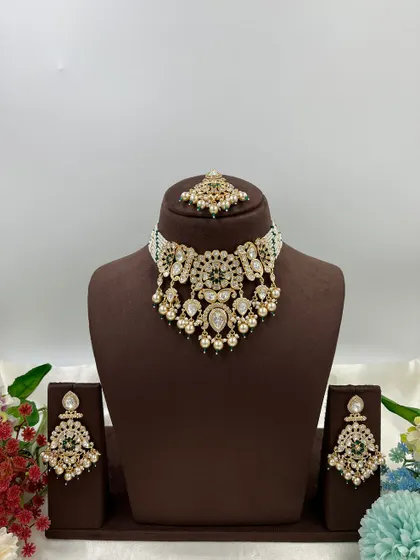 This collection showcases our premium Moissanite Kundan necklaces like the 'Noor Nazaakat' and 'Darbaar' sets. Each comes with a full set of earrings and maang tikka, available in various color combinations.