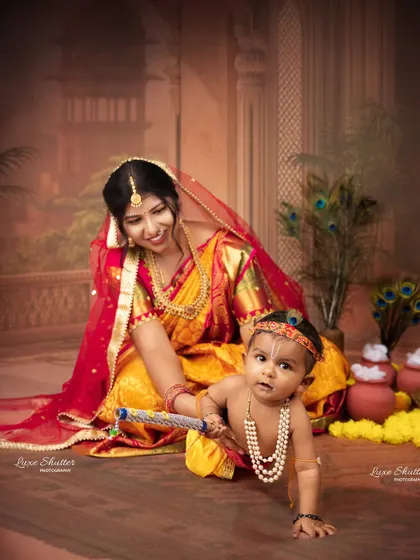 A playful moment from the Krishna-themed shoot, capturing the baby crawling while his mother looks on with a smile.