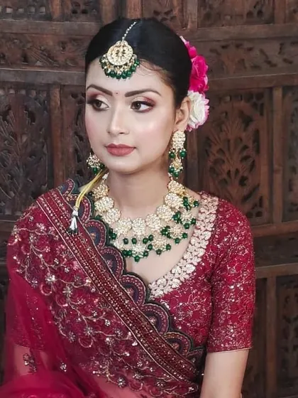 A simple and elegant bridal look. The Kundan necklace with green beads and matching maang tikka is perfect for a bride who wants a classic and understated style.
