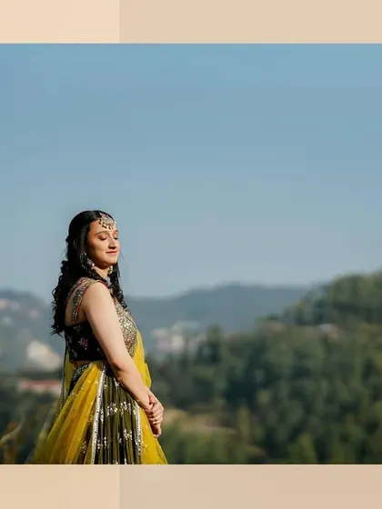 A beautiful wide shot of the bride at her outdoor Mehandi, with the mountains in the background. It connects the traditional celebration with the destination.