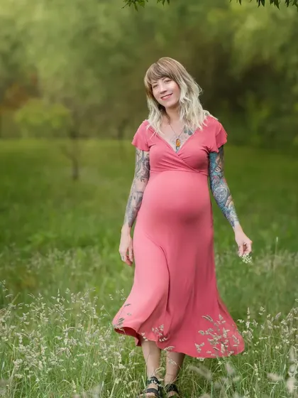A joyful mother-to-be walking through a field of wildflowers. Her smile and the movement in her dress create a feeling of freedom and happiness.