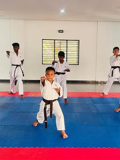 A student at the front of the class demonstrates a powerful punch during the grading.