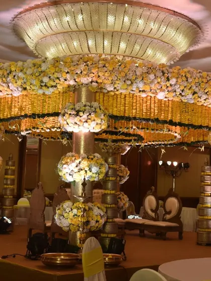 Another perspective of the grand marigold mandap, showing how the floral rings are layered to create depth and opulence. The design works in harmony with the hotel's magnificent crystal chandelier.
