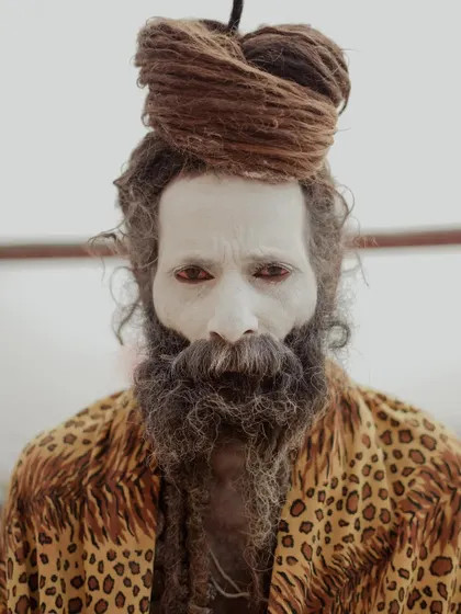 A striking portrait of an Aghori sadhu, his face painted and his gaze intense. This image captures the ascetic and often misunderstood side of spirituality found in Varanasi.