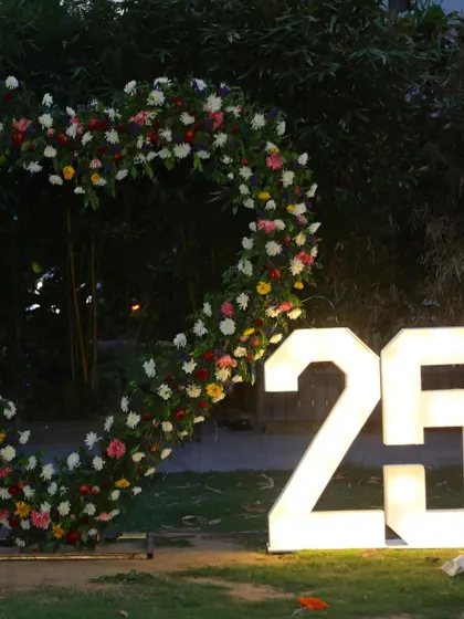 A close-up of the heart-shaped floral arch and the light-up marquee numbers.