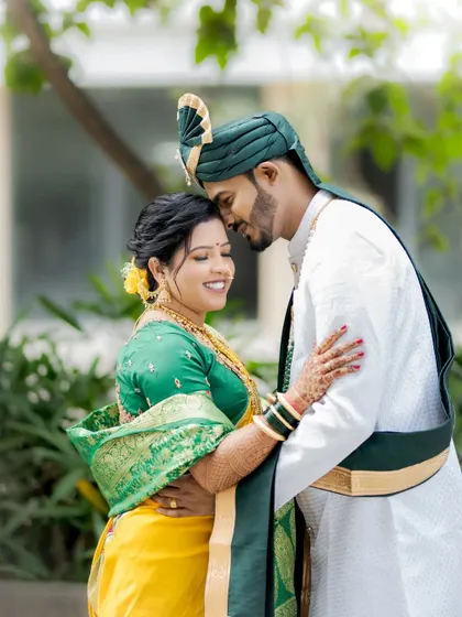 A romantic portrait with the groom gently touching his forehead to his bride's, both smiling with contentment.