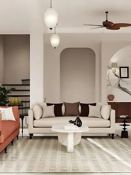 Another view of the living room, highlighting the interplay of color and form. The space is designed to feel balanced and simple, where the vibrant coral-pink sofa provides a focal point against the minimalist backdrop of white walls and marble accents.