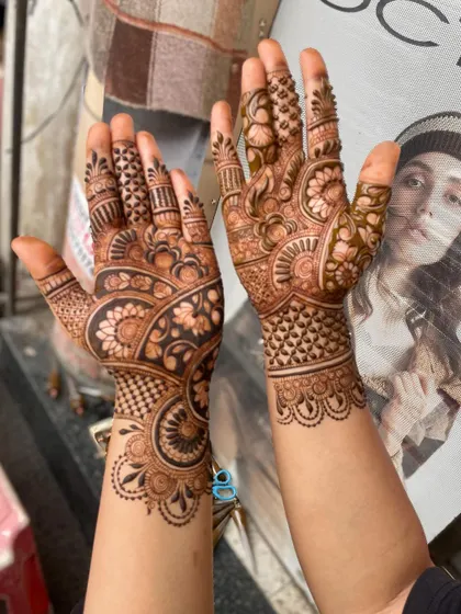 A beautiful, full-hand design with a mix of floral, paisley, and check patterns. This is a classic and timeless mehandi style.