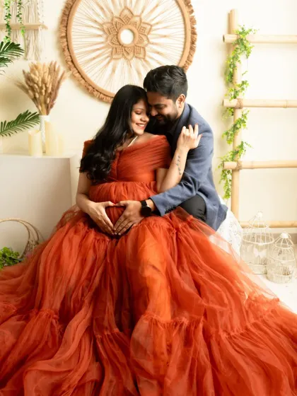 An intimate embrace with the couple's hands forming a heart on the bump. A timeless expression of love for their unborn child.