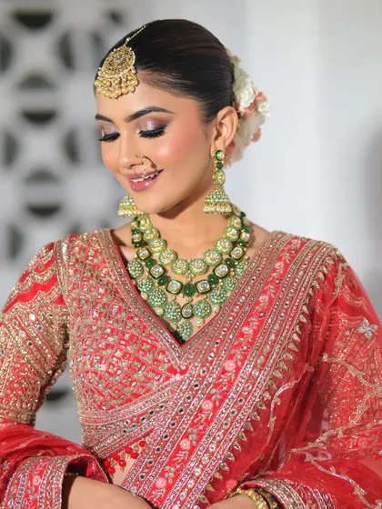 A soft and happy moment captured. The bride's smile is enhanced by the warm, glowing makeup and the beautiful floral hair accessory.