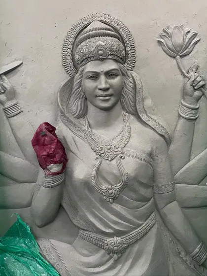 A close-up of the clay sculpting process for the Maa Durga mural. Every detail, from the expression on her face to the adornments, is carefully shaped by hand before casting.