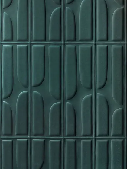 A close-up of the 'Le sentier des effluves' 3D wallcovering from Élitis. The fusion of a soft suede texture and a geometric pattern creates a multidimensional landscape of gentle, quilted shapes.