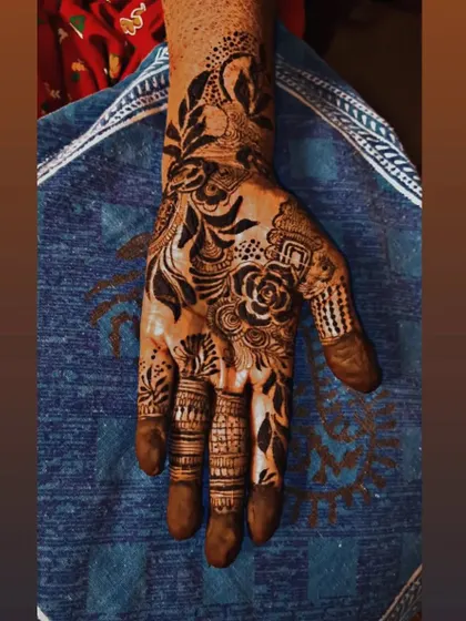 This is a pure Arabic style with a focus on bold, dark shading. The design features a large floral and leaf pattern that sweeps across the hand, making a dramatic statement.