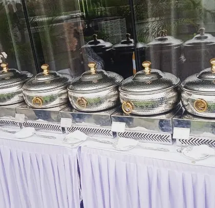 A beautiful outdoor terrace setup for a corporate lunch for Sudha Carpets. The hammered-steel chafing dishes and fresh floral arrangements elevate the dining experience.