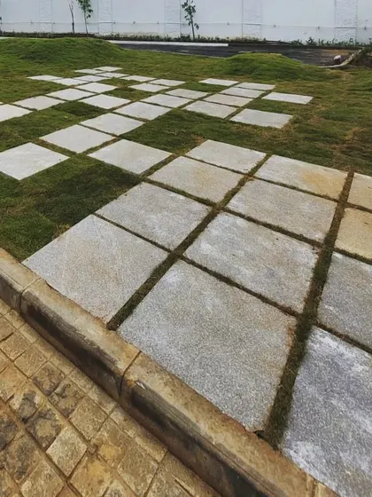 The 'giant tetris' paving connects seamlessly with the adjacent cobblestone path, showing a thoughtful transition between different materials and textures within the same landscape.