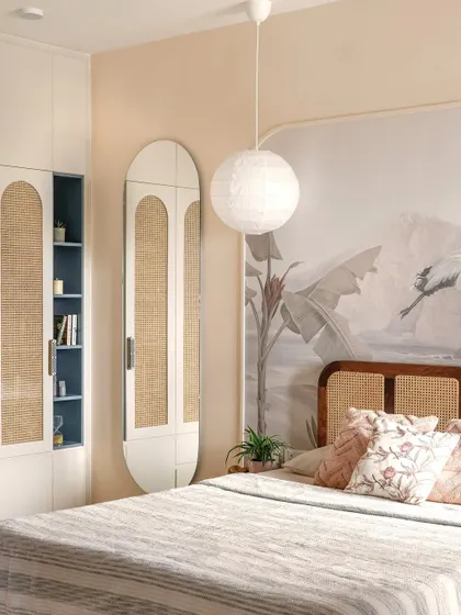 A closer look at the bedroom's clever storage solutions. The wardrobe features cane-paneled doors and an open shelving unit in a contrasting blue, adding both personality and practicality.
