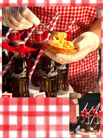 A playful shot from the burger station, showing a waffle topped with cheese sauce next to classic Coca-Cola bottles, adding to the nostalgic American diner theme.