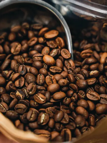A close-up shot of fresh coffee beans. The rich brown tones and detailed texture instantly communicate quality and the promise of a fresh, aromatic brew.