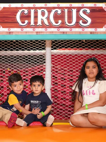 Siblings sitting together in the play area.