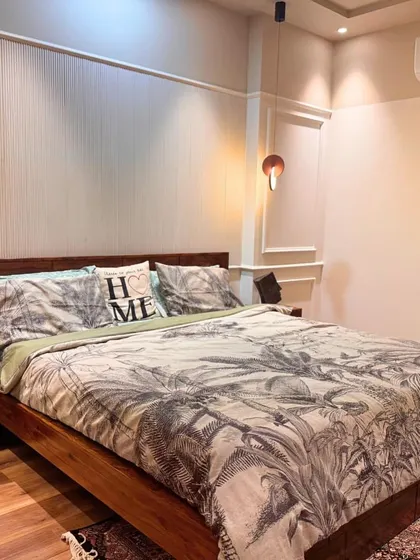 This bedroom design features clean lines and a simple color palette. The "HOME" pillow adds a charming touch, while the minimalist bedside tables keep the space uncluttered.