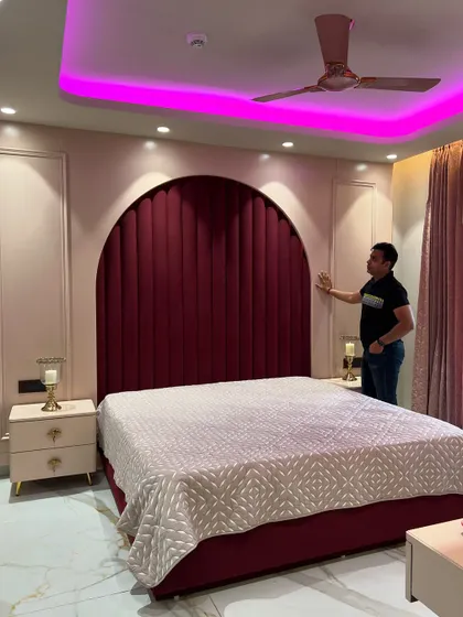 Another angle of the red velvet arched headboard, showing the detailed paneling on the surrounding wall.