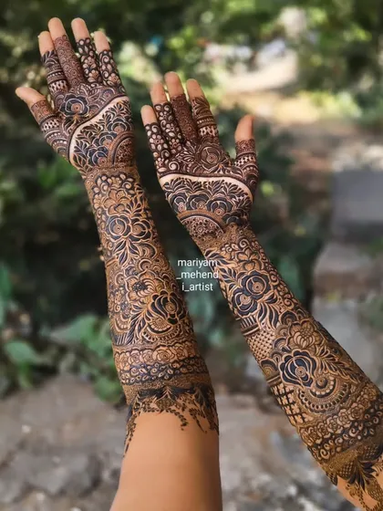 Intricate floral and paisley patterns covering the entire arm for a traditional bridal look.