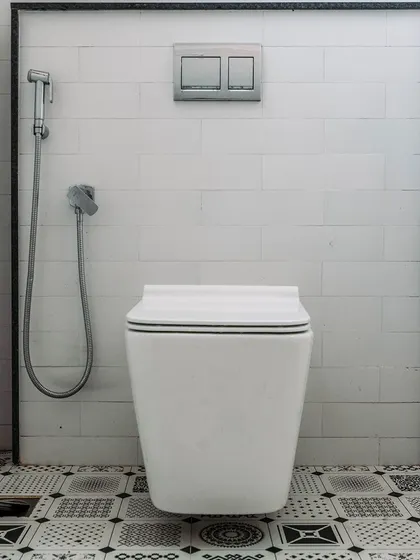 A study in black and white. The geometric pattern of the floor tiles contrasts with the simple white subway tiles on the wall, creating a bold and graphic bathroom design.