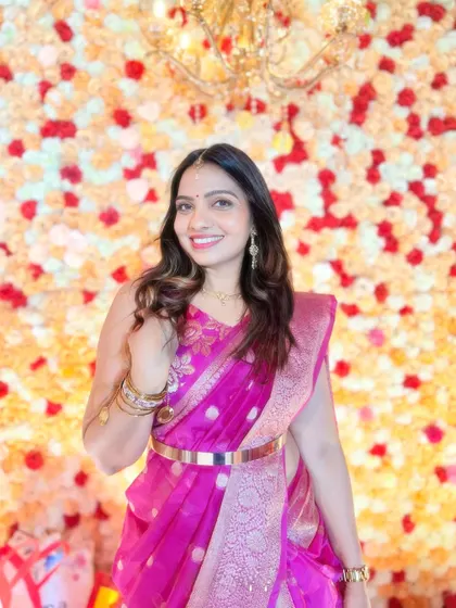 A smiling shot against a beautiful floral backdrop. This saree-lehenga combination is perfect for wedding guests who want to stand out.