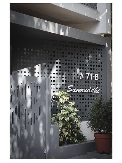The house number and name, 'Samruddhi', are integrated into a perforated metal screen at the entrance, demonstrating our attention to even the smallest details.