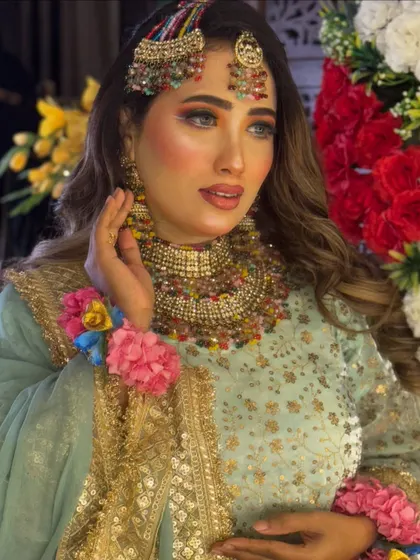 The complete Haldi look is fresh, colorful, and celebratory. The makeup enhances her features while complementing the bright colors of her jewelry and flowers.