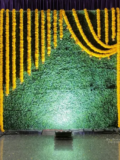 A duplicate image of the simple backdrop with a green mat and marigold garlands.