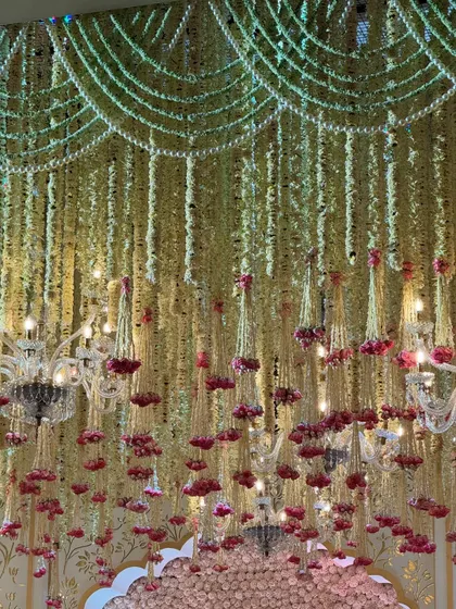 A look up at the symphony of soft blooms and golden accents. The floral ceiling, interspersed with small chandeliers, creates a magical, fairytale-like canopy. 🌸✨