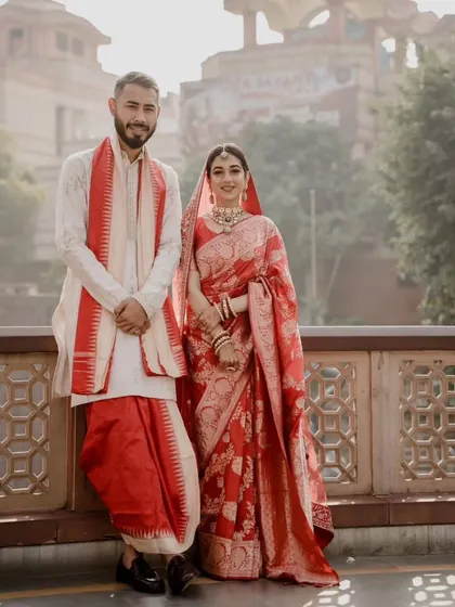 A stunning portrait of a couple in their traditional Bengali wedding attire. The red and white color scheme is classic and beautiful.