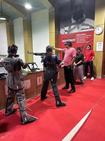 A coach provides hands on guidance to our young rifle shooters at the range. This personalized attention is crucial for correcting form and building a strong technical foundation.