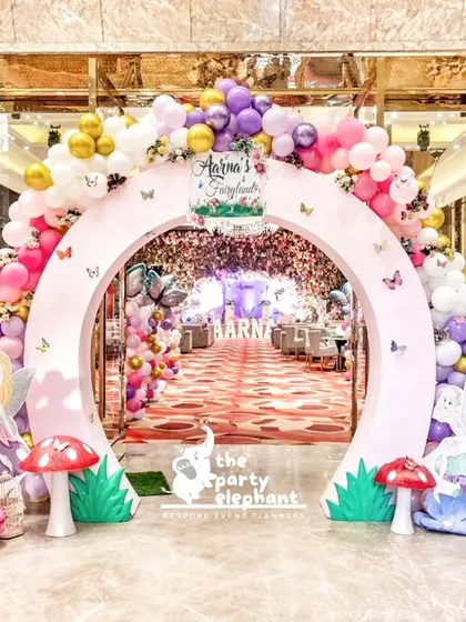 For this first birthday, I designed an enchanting 'Butterfly Fairyland' entrance. A large circular arch covered in pastel balloons and butterflies framed the view into the grandly decorated party hall.